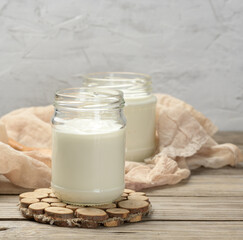 homemade yogurt in a glass transparent jar on a wooden table