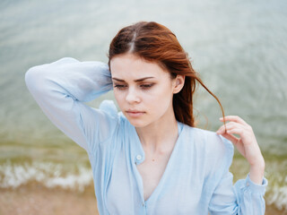 Happy woman in a transparent shirt near the sea on the beach on the beach