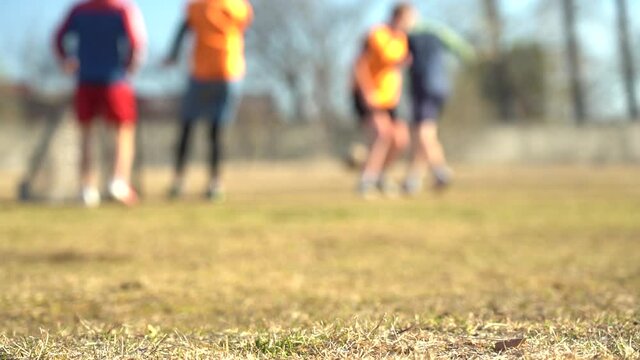Blurred video. Slow motion. Legs of young soccer players during the game in training