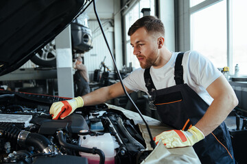 technician working on checking and service car in  workshop garage
