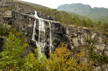 waterfall with dark mountain wall in norwegian landscape - 429595201