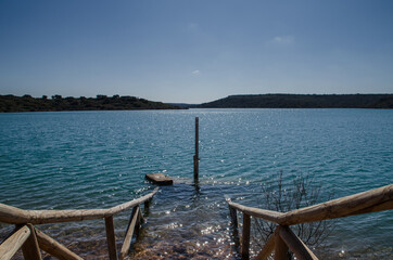 wooden walkway at the entrance to a swamp with mountains in the background