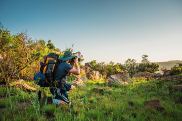 Male hiker taking a photograph in Suikerboschfontein  in Mpumalanga, South Africa. November 2018