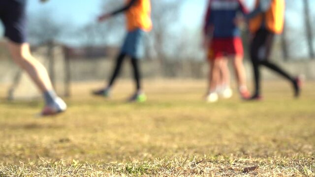 Blurred video. Slow motion. Legs of young soccer players during the game in training