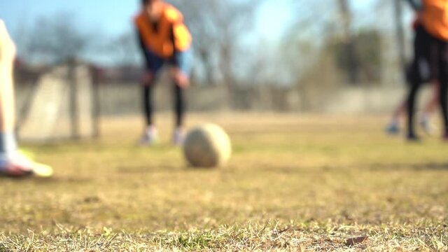 Blurred video. Slow motion. Legs of young soccer players during the game in training