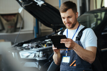 Mechanic engineer taking a note on clipboard for examining a vehicle