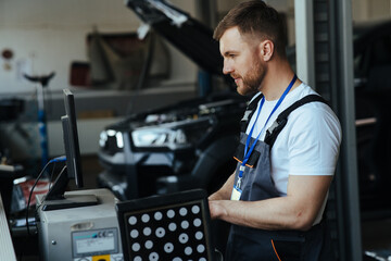 Car mechanic installing sensor  adjustment and automobile wheel - obrazy, fototapety, plakaty