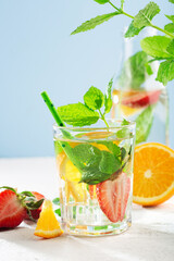 Summer detox beverage concept. Citrus fruit drinks with ice. Healthy diet cocktail with fresh berries and mint