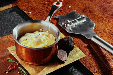 Corn kernels in bechamel sauce with cheddar cheese served in a saucepan on a copper background.