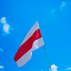 
Isolated waving Belarusian national flag on blue sky background with clouds . White-red-white flag. A symbol of peaceful protests in Belarus against the dictatorship after presidential elections.