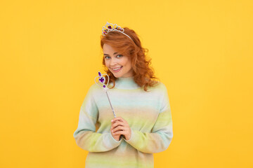 happy redhead woman in queen crown with magic wand, wish