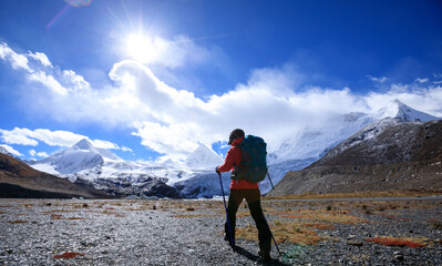 Fototapeta premium Woman hiker hiking in high altitude winter mountains