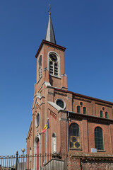 Fototapeta na wymiar Country church in Belgium Flanders Zonnegem against blue sky