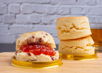 English style scones delicious freshly baked homemade on wooden tray and teacup placed on wooden table. Dessert, beverage, and relaxation concept