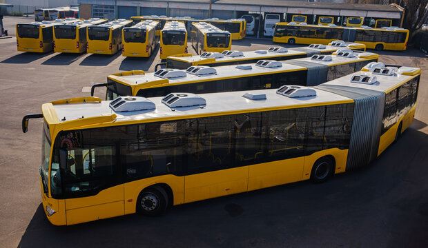 a group of yellow buses in a parking lot in berlin. local public transport