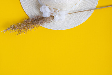 White women hat and reed branch. Yellow Background. Wedding concept. Summer concept.