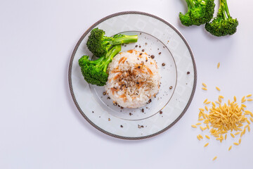Rice with barley noodles and fresh broccoli on the plate.
