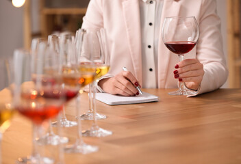 Sommelier tasting different sorts of wine at table indoors, closeup