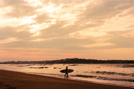 person walking on the beach at sunset