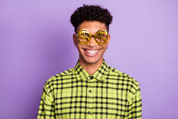 Portrait of attractive funny cheerful brunet guy wearing dollar sign specs isolated over violet purple color background