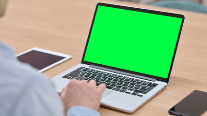 Man Working on Laptop with Green Chroma Key Screen