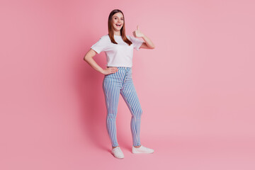 Charming promoter lady showing thumb up on pink background