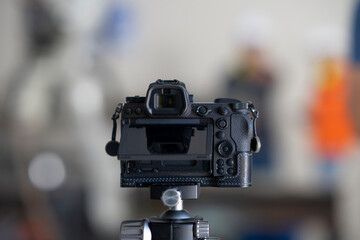 The camera is placed on a tripod with a blurred background.