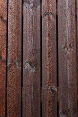 Texture of vintage style barn wall made from homemade rough sawn timber. Knotty boards treated with varnish and pine tar.