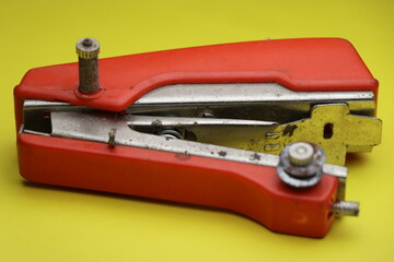 portable sewing equipment which is mini machine for sewing clothes on yellow background