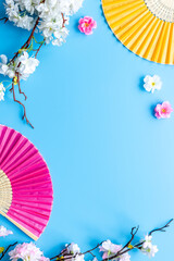 Japanese hand fan with cherry blossom branch. Top view