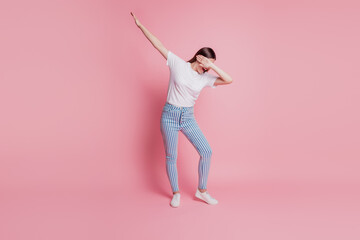 Portrait of a happy young woman dancing make cool move dab