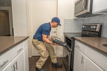 Appliance repairman working on a oven door
