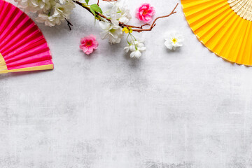 Japanese hand fan with cherry blossom branch. Top view