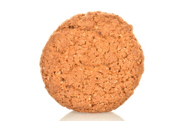 One fragrant dark brown oatmeal cookie, close-up, isolated on white.
