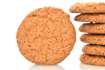 Several fragrant dark brown oatmeal cookies, close-up, isolated on white.