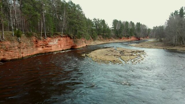 Red rocks and river Salaca. Sandstone cliff in Latvia, flying with drone in Gauja National Park