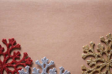 Brown paper background decorated with red, gold, and silver ice models for Christmas day.