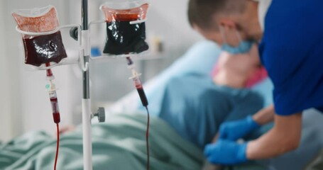 Nurse injecting syringe in female patient arm for blood transfusion - Powered by Adobe