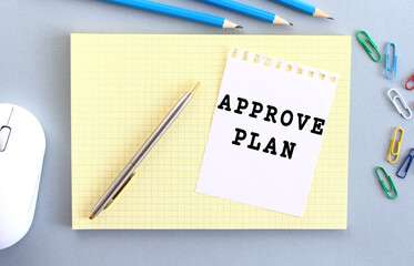 APPROVE PLAN is written on a piece of paper that lies on a notebook.