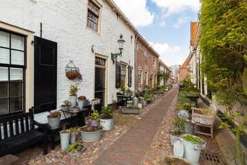 Small street with old small and authentic houses and flowers in the center of Elburg in the Netherlands.