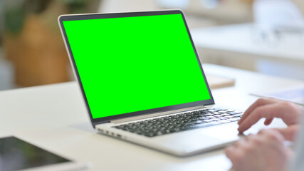 Fototapeta na wymiar Young Man using Laptop with Green Chroma Screen 