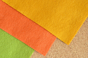 Fototapeta premium Orange and green and yellow felt fabric on the brown recycle board.