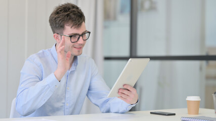 Young Man making Video Call on Tablet in Office 