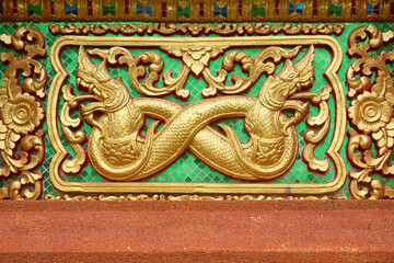 Golden stucco wall art in Thai temples