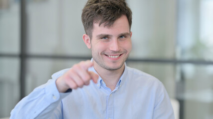 Naklejka premium Positive Young Man Pointing at the Camera 