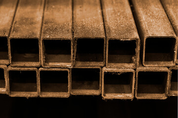 Square iron pipes. Side view, indoors horizontal shot.