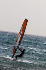 windsurfer surfing the wind on emerald sea waves, extreme water sport, healthy active lifestyle,...
