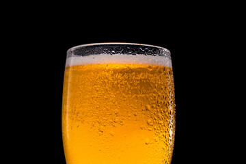 Frosty glass of light beer isolated on a black background.
