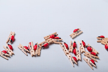 Small wooden decorative pins with tiny red ladybugs for handwork, handmade decorations, leisure time with children. Spring and love concept. Copy space.