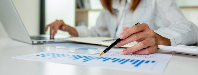Financial Businesswomen analyze the graph of the company's performance to create profits and growth, Market research reports and income statistics, Financial and Accounting concept.